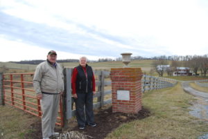 Don and Sue Hanger by the entrance gate to Berry-Moore Farm